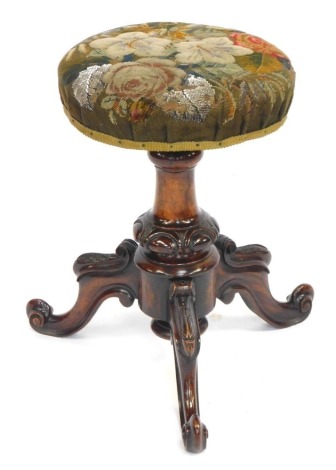 A Victorian walnut rise and fall piano stool, with woolwork and beaded seat, jewel carved baluster stem, and three scroll legs.