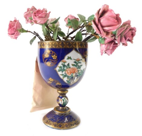 A Samson Chinese style porcelain and enamel flower vase, with ceramic pink roses, in a royal blue goblet with gilt decoration and floral painted panels, 18.5cm high. (AF)