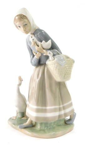 A Lladro porcelain figure group of a lady and geese, 21cm high.