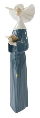 A Lladro porcelain figure of a nun, 24cm high.