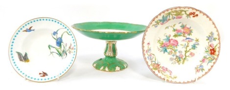 Three 19thC and later porcelain plates, comprising a 19thC cake stand, with green gilt border, and central ruin, 13cm high, a Minton saucer with turquoise border, painted with birds and flowers, 16cm diameter, and a Minton bowl, 19cm wide. (3)