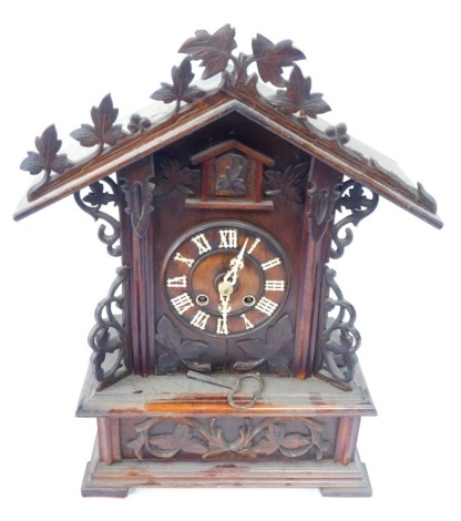 A 19thC Black Forest pine mantel clock, the arched top with vine and berry detail, with bone Roman numeral markers, and hands, 53cm high, 35cm wide, 18cm deep.