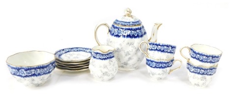 An early 20thC Coalport part tea service, decorated on a blue and white ground flowers, picked out in gilt, comprising teapot, four cups and saucers, milk jug and sugar bowl.