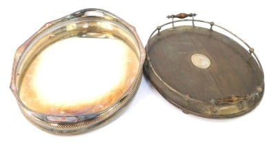 Two serving trays, comprising a silver plated oval serving tray with pierced borders and oak and plate gallery mounted tray, the largest 64cm diameter, the smallest 55cm diameter. (2)