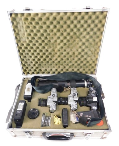 An aluminium camera carry case and contents, comprising Zenit EM Helius 44mm camera, a Zenit EM camera with Helius 44mm lens, a Zenit - E camera, two flashes, lens caps and cases, and a Soligor Tele Auto 1-6.3mm lens, all in fitted carry case.