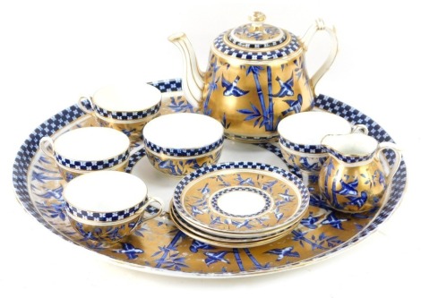 A 19thC Coalport Tete a Tete service, with royal blue bamboo and swallow design on a gilt border, comprising large circular serving tray, teapot, milk jug, sugar bowl and four tea cups and saucers, 44cm diameter. (AF)