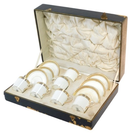 A Crescent porcelain coffee can set, produced for Harrods Ltd, on plain white ground with gilt floral border, comprising six coffee cans and saucers, in fitted case.