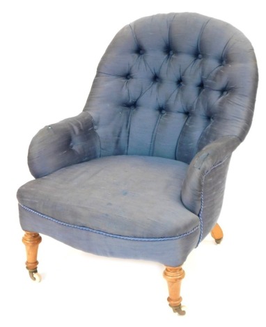 A Victorian button back low armchair, with turned walnut four legs and castors.