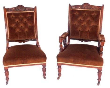 A pair of late Victorian and walnut salon chairs, being gentleman's armchairs, with a leaf carved crest, button padded back arm rests and seat, on turned tapering legs with castors, and a matching lady's chair. (2)