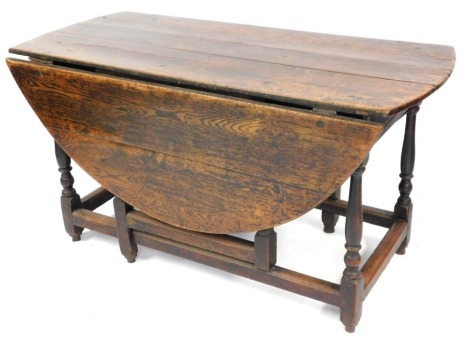 An 18thC oak gate leg table, the oval top on turned supports with plain stretcher, 71cm high, 130cm wide.