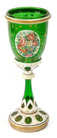 A 19thC Bohemian glass goblet, lid lacking, in green glass with cream borders and gilt surround, with floral panel, 35cm high.