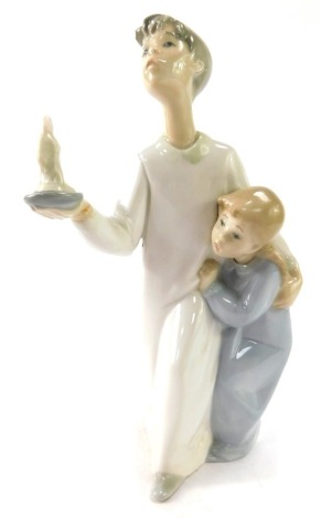 A Lladro figure of a father and child, carrying lantern, 20cm high.