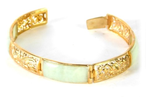 A 9ct gold and jade bracelet, of six sectional design, with three rectangular panels of light jade and four pierced Eastern style panels, 19cm long, 17.1g all in.