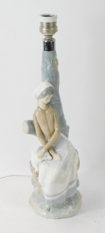 A Nao porcelain table lamp, depicting a lady with a lamb on tree branch, 41cm high.