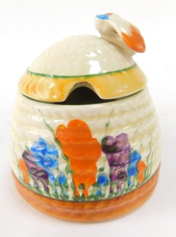 A Clarice Cliff beehive preserve jar and cover decorated in the crocus pattern, 7cm high.