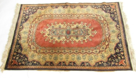 A Turkish rug, red ground decorated with a central oval medallion with floral motifs, within repeating foliate and floral borders, 182cm x 120cm.