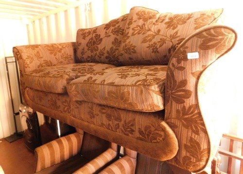 A two seater brown floral sofa.