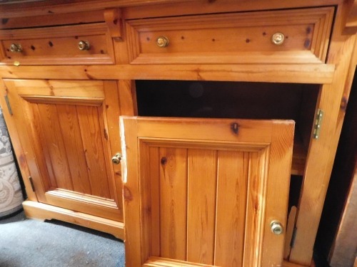 A pine kitchen dresser with plate rack and two door and two drawer base, 126cm wide.