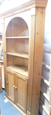 A stripped and waxed pine freestanding corner cupboard, with barrel back, in the Georgian style.