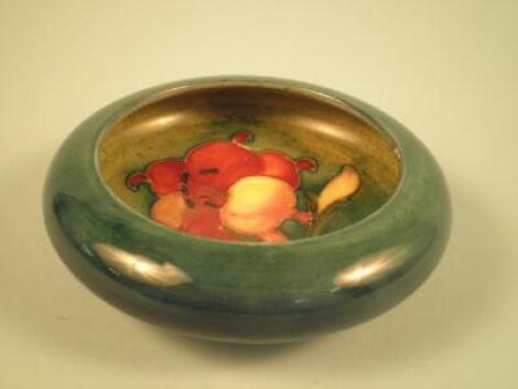 A Moorcroft Fresia pattern small bowl or ashtray on a green and blue ground