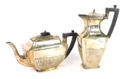 A George V two piece silver service, by the Atkin Brothers, comprising water jug and teapot, 24cm high, each with ebonised angular handles, part fluted decoration, Sheffield 1929, 35½oz all in.