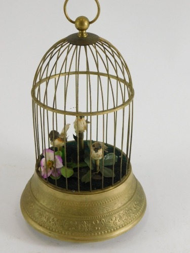 A gilt metal bird cage automaton, containing three birds on a tapering base, cast with scrolls, leaves etc., unmarked 33cm high.