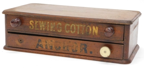 A Clark's mahogany cotton reel box, with trademark advertising brand elephant to the top, with two drawers, stencilled with Sewing Cotton and an anchor, 56cm wide