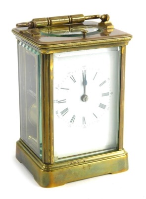 An early 20thC brass repeating carriage clock, in rectangular case with back plate, Roman numeric dial, on stylised bracket feet, in a five part glazed case with plain plate back, key wind barrel movement, and repeat button, 13cm high, in outer case.