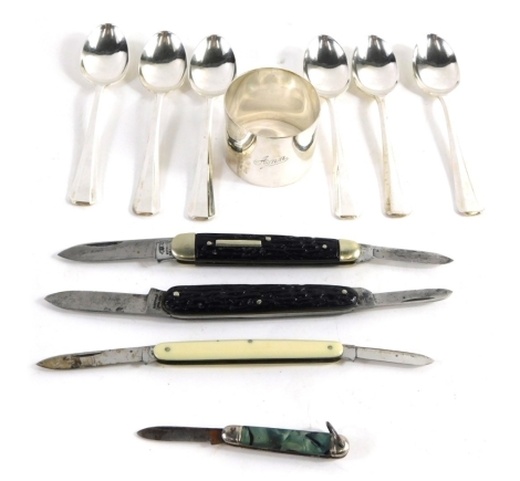 Three raised penknives, a silver napkin ring of plain form, and a cased set of plated teaspoons, the case 17cm wide.