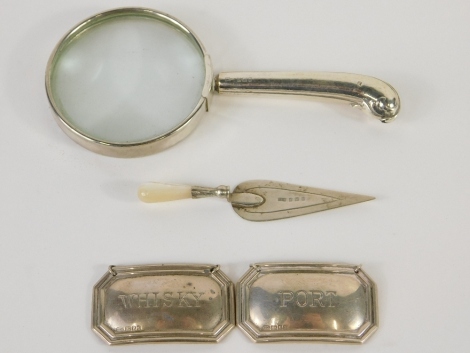 An Edward VII silver and mother of pearl trowel bookmark, Birmingham 1908, 8cm wide, a silver handled magnifying glass and a port and whisky label. (4)