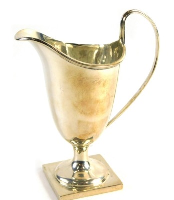 A George V helmet shaped cream jug, with strap work handle on square foot, Birmingham 1910, 13cm high, 2.5oz.