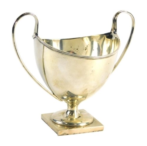 A George V silver two handled sugar bowl, with helmet shaped body, strap work handles, inverted stem and square foot, Birmingham 1910, 12cm high, 3.2oz.