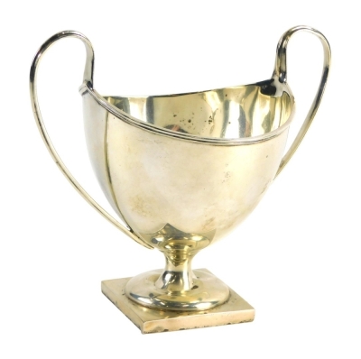 A George V silver two handled sugar bowl, with helmet shaped body, strap work handles, inverted stem and square foot, Birmingham 1910, 12cm high, 3.2oz.