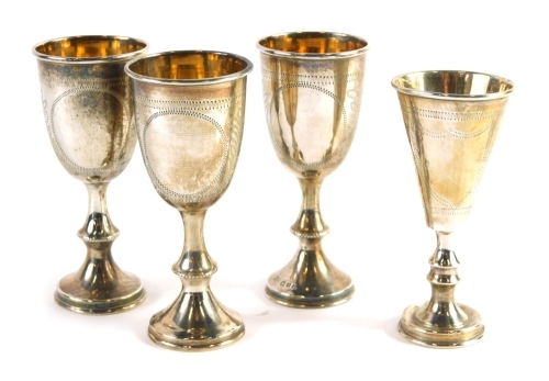 Three George V miniature silver goblets, crested on shaped stems and circular feet, with silver gilt interiors, London 1933, and another similar 1933, 9cm high, 4.7oz. (4)