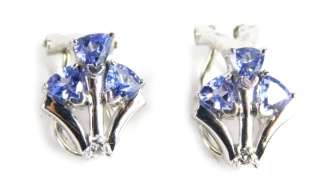 A pair of tanzanite earrings, each claw set with three stones, 1cm high. (2)