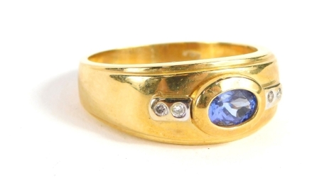 A dress ring, with oval blue stone flanked by two small white stones, on a textured shank, marked 18k, size U. (boxed)