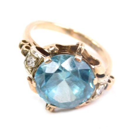 A dress ring, claw set with a large blue zircon, the part pierced shank inset with two diamonds, unmarked, size M.