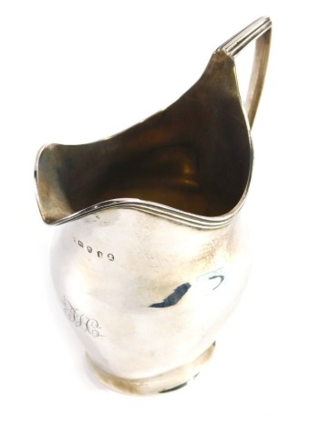 A George III silver cream jug, helmet shaped with angular strap handle on oval foot, London 1804, 13cm high, 4oz.