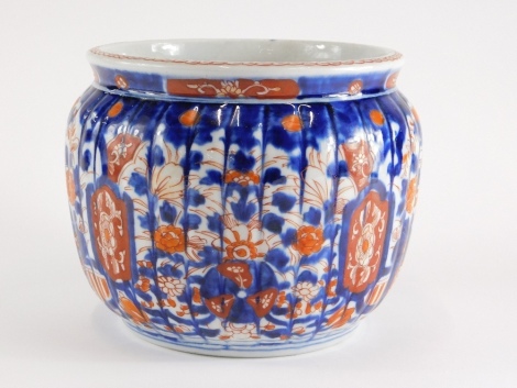 A Japanese Imari porcelain jardiniere, with ribbed body and decorated with flowers, leaves, etc., 17cm high.