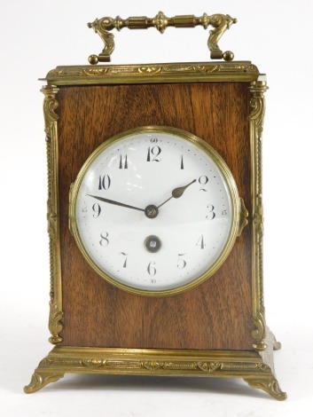 A French mahogany and brass carriage timepiece, with hinged handle, with white enamel dial with Arabic numerals, on bracket feet 25cm high.