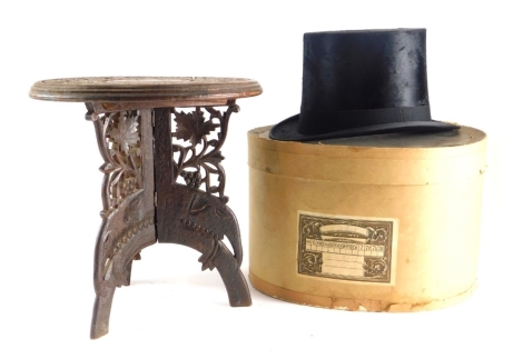 A heavily carved Eastern side table, with a repeat star and floral pattern to the circular top, 30cm diameter, and a small Dunn & Co top hat, size 32/6, partially boxed.