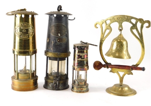 A 20thC Thomas and Williams miner's lamp, of cylindrical form with glass centre, 26cm high, another miniature example marked Thomas and Williams, and a further miner's lamp. (3)