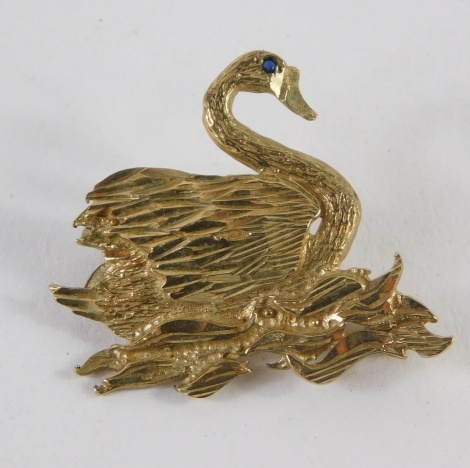 A 9ct gold swan brooch, the eye set with blue stone, 3cm wide, 4g.