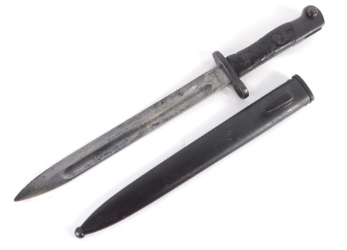 A bayonet and plain scabbard, with textured blade and turned hilt, set with Chinese lettering, 38cm long.