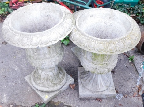 A matched pair of HCC marked Victorian style concrete urns, of classical form, each with an acanthus leaf body, on square plinth bases, 61cm high.