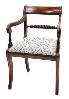 A Regency mahogany open armchair, the bar back carved with flowers, scrolls, etc., with a drop in seat, on sabre legs, and another similar (AF). (2)