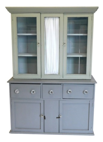 An pine dresser, the top with two glazed doors, the base with a moulded edge above three frieze drawers and two panelled doors, on a plinth, associated and later painted two shades of grey, 182cm high, 122cm wide.