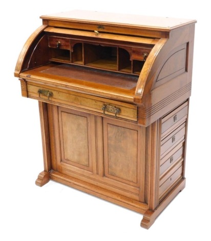 A late 19thC walnut and figured walnut cylinder desk, the top with a moulded edge above a panelled door enclosing a fitted interior, with a frieze drawer and two panelled doors, on reeded supports, (AF), 70cm wide.