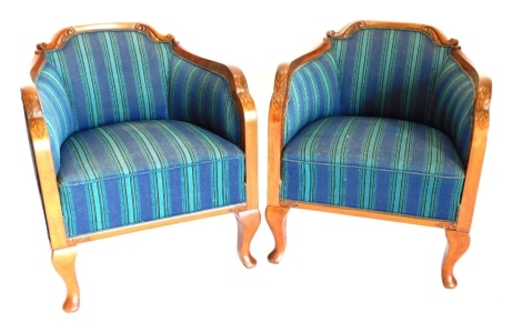 A pair of 1920s mahogany tub shaped chairs, each with leaf carved and shaped show frame, upholstered in striped fabric, on cabriole legs with pad feet.