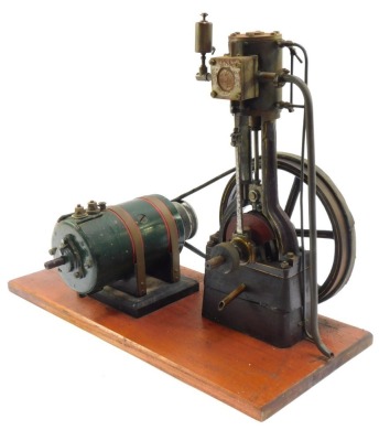 A vertical steam engine, with fly wheel and motor, on a wooden plinth, 60cm wide, 44cm high, 25cm wide.